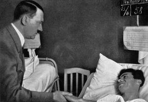 Adolf Hitler besucht die Opfer des Unglücks im Sprengstoffwerk Reinsdorf im Krankenhaus in Wittenberg (Sachsen-Anhalt) 1935. Zigarettensammelbild. (Bayerische Staatsbibliothek, Bildarchiv hoff-10749)