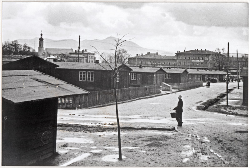 Das Grenzdurchgangslager Furth im Wald wurde 1945 nördlich das Bahnhofes eingerichtet. Es war die erste Anlaufstelle für zahlreiche nach Bayern kommende Flüchtlinge und Vertriebene. Diese Erstaufnahmestationen dienten zunächst der Registrierung und Erstversorgung. Anschließend sollten die Flüchtlinge und Vertriebenen rasch auf andere Unterkünfte im ganzen Land verteilt werden. Diese Umverteilung stockte allerdings vielfach aufgrund mangelnden Wohnraums, so dass zeitweise bis zu 6.000 Personen bis in die 1950er Jahre dauerhaft in der Erstaufnahmestation lebten. Das Bild zeigt die Lagerbaracken 1946 mit Blick in Richtung Bahnhof. (Sudetendeutsches Archiv, Bildersammlung 21379, mit Genehmigung des Stadtarchives Furth im Wald)