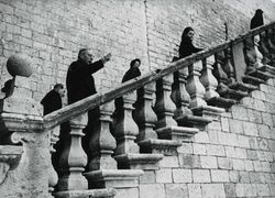 Weihbischof Johannes Neuhäusler auf der Treppe in Assisi während eines Aufenthalts im Rahmen einer Pilgerreise nach Rom, den Weg weisend. (Archiv des Erzbistums München und Freising, EA004/2, 629)
