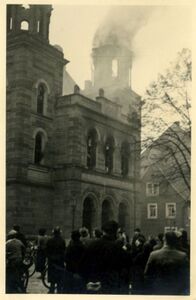 Brand der Synagoge in Kitzingen am 10. November 1938, im Vordergrund schaulustige Passanten. Fotografie von Rudolf Wolfarth. (Stadtarchiv Kitzingen, Historische Fotosammlung)