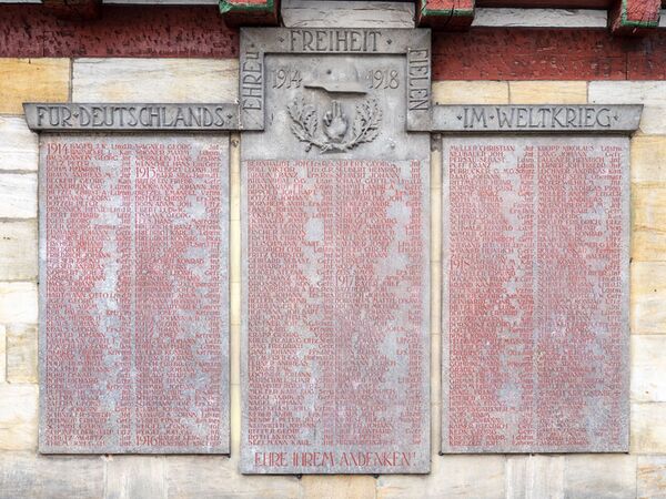 Das Forchheimer Kriegerdenkmal besteht aus dem 1927 errichtetem sog. Kriegerbrunnen des Künstlers Georg Leisgang (1893-1970) und der hinter dem Brunnen an einem mittelalterlichen Fachwerkhaus angebrachten Tafel der Gefallenen (hier zu sehen). (Fotografie von Reinhold Möller, lizenziert durch CC-BY-SA 4.0 via Wikimedia Commons)