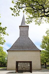 Mahnmal für die Opfer des Nationalsozialismus im Stadtpark von Traunstein vor der ehemaligen Friedhofskirche St. Georg und Katharina. Der Metallkubus wurde 1994 vom Künstler Rolf Wassermann (geb. 1964) geschaffen. (Fotografie von Rufus46, lizenziert durch CC-BY-SA-3.0 AT via Wikimedia Commons)