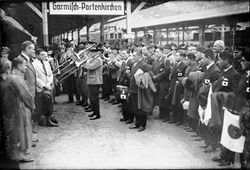Ankunft der japanischen Olympioniken am Bahnhof Garmisch-Partenkirchen. Links im Bild: Bürgermeister Jakob Scheck, Reichssportführer Karl von Halt und Journalist Peter von Le Fort. Fotografie von August Beckert. (Bayerische Staatsbibliothek, Bildarchiv ansi-005707)