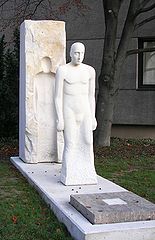 Im Jahr 2006 wurde in Waldkraiburg ein Mahnmal der Vertreibung eingeweiht. Geschaffen hat es der aus dem schlesischen Deutsch-Piekar (Polen) stammende und in Waldkraiburg beiheimatete Bildhauer Matthäus Rutkowski (geb. 1975). Das Mahnmal zeigt eine aus einem Monolith herausgearbeitete Figur und ist aus Warthauer Sandstein aus Schlesien gearbeitet. Es stellt die Entwurzelung der Vertriebenen aus der Heimat dar. (Foto: Stadtarchiv Waldkraiburg)
