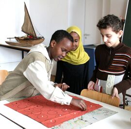 Im Rahmen des MPZ-Projektes "Komm, wir lernen Deutsch im Museum!" für Kinder und Jugendliche mit Zuwanderungshintergrund spielen hier Kinder einer Übergangsklasse (Ü-Klasse) mit einem selbstgebastelten Spiel im Staatlichen Museum für Völkerkunde (seit 2014: Museum Fünf Kontinente) in München. (Foto: MPZ)