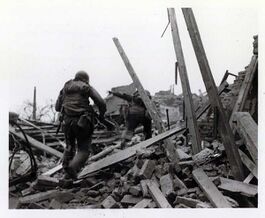 US-amerikanische Infanteristen in Ruinen des Aschaffenburger Stadtteils Schweinheim, 2.4.1945. (gemeinfrei via Wikimedia Commons)