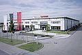 Das 1997 in Meerane (Sachsen, Lkr. Zwickau) errichtete Werk ist der erste Standort zur Herstellung von Türsystemen, die im Takt der Fahrzeugproduktion des Automobilherstellers - just in sequence (JIS) - gefertigt und direkt an das Montageband geliefert werden. (Brose Fahrzeugteile GmbH & Co. Kommanditgesellschaft, Coburg)