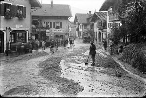 Partenkirchen, Ludwigstraße: Das Hochwasser der Partnach richtete am 13. August 1932 in Partenkirchen schwere Schäden an. Unter anderem zerstörten die Wassermassen die Bahntrasse, Wege und Heustadl. Das Bild zeigt die Aufräumarbeiten. (Bayerische Staatsbibliothek, Fotoarchiv Johannes, ansi-6440)