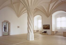 Die Herzogliche Stube mit der gedrehten spätgotischen Säule, Blick zu den Fensternischen und dem Durchgang in das Stulfenster (rechts). (Bayerisches Armeemuseum Ingolstadt/Foto: Christian Stoye)